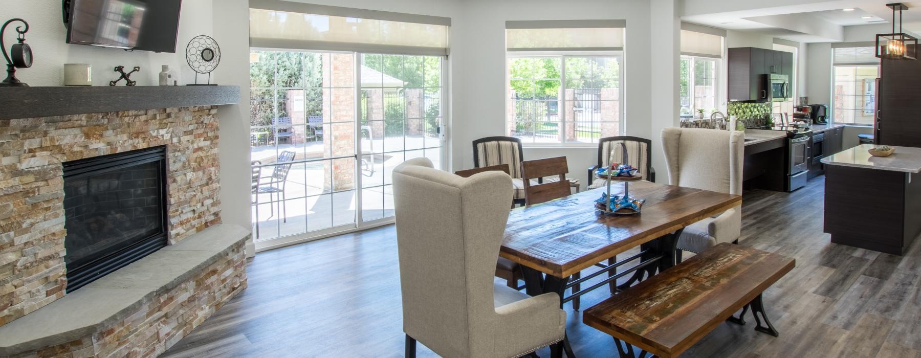 a lounge with a fireplace and dining room table