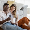 a couple sitting on the ground looking at a phone